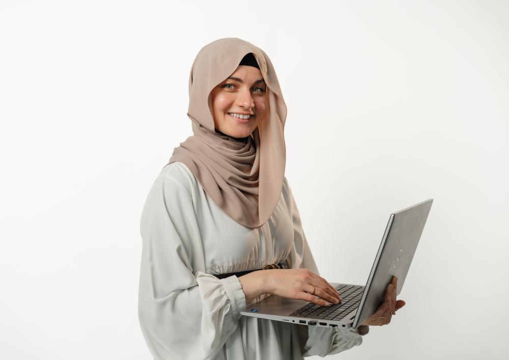 Dame met hoofddoek met laptop in de hand
