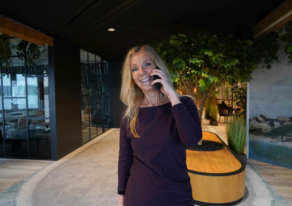 Medewerker kijkt bellend in de camera