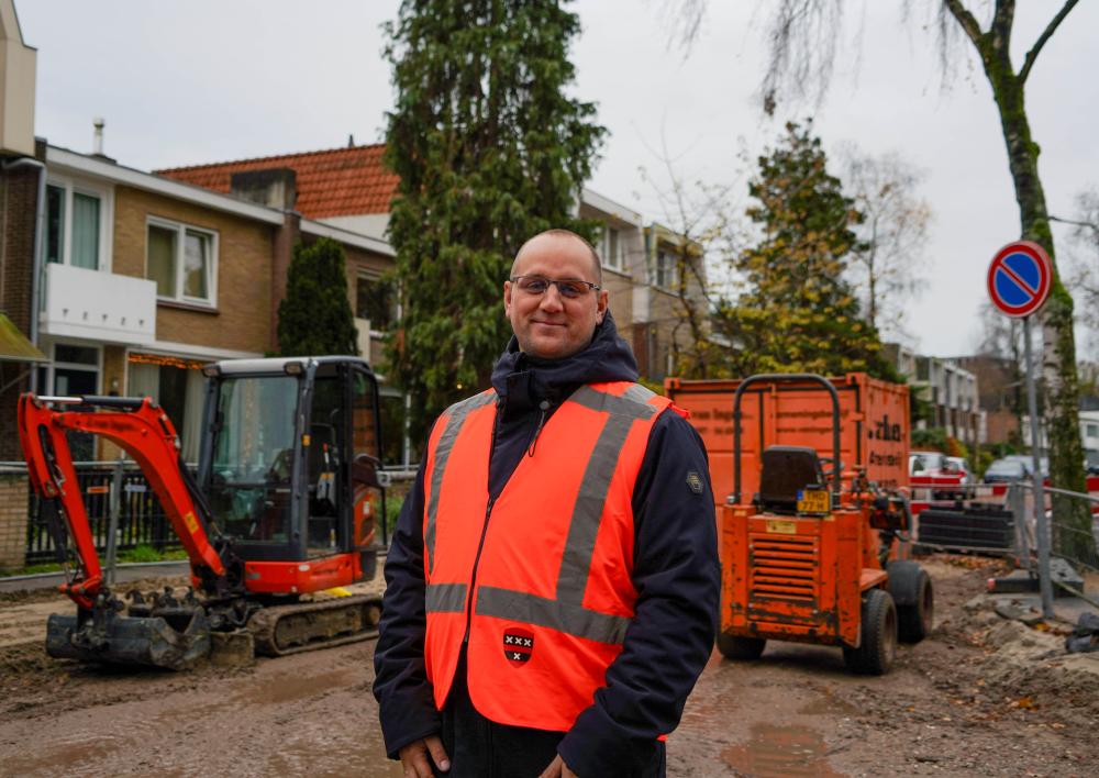 Jacob Pijper staat voor een opengelegde straat met werkzaamheden
