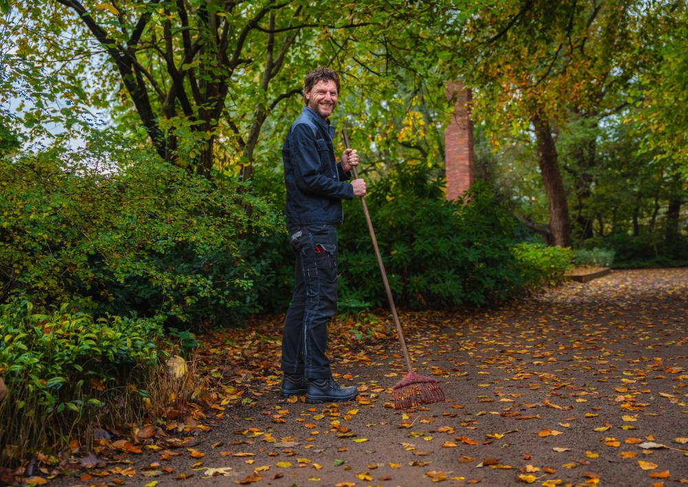 Medewerker in een park met hoveniersgereedschap