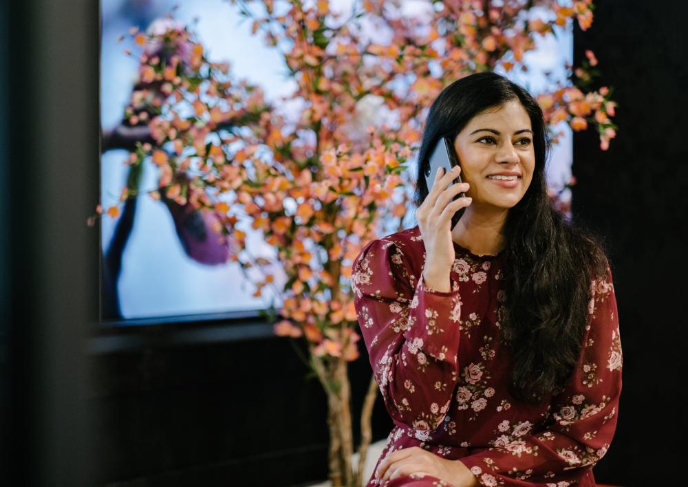 vrouw met donker haar heeft telefoon vast bij haar oor