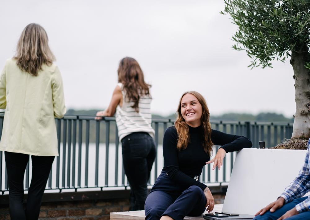Collega zit lachend op een bankje buiten