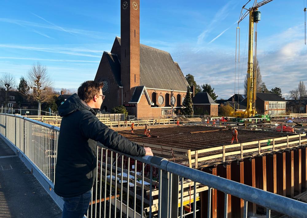 Tom kijkt vanaf de brug naar de werkzaamheden aan de A9