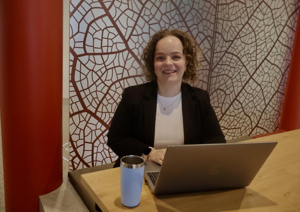 Maxime aan tafel met laptop en een koffie