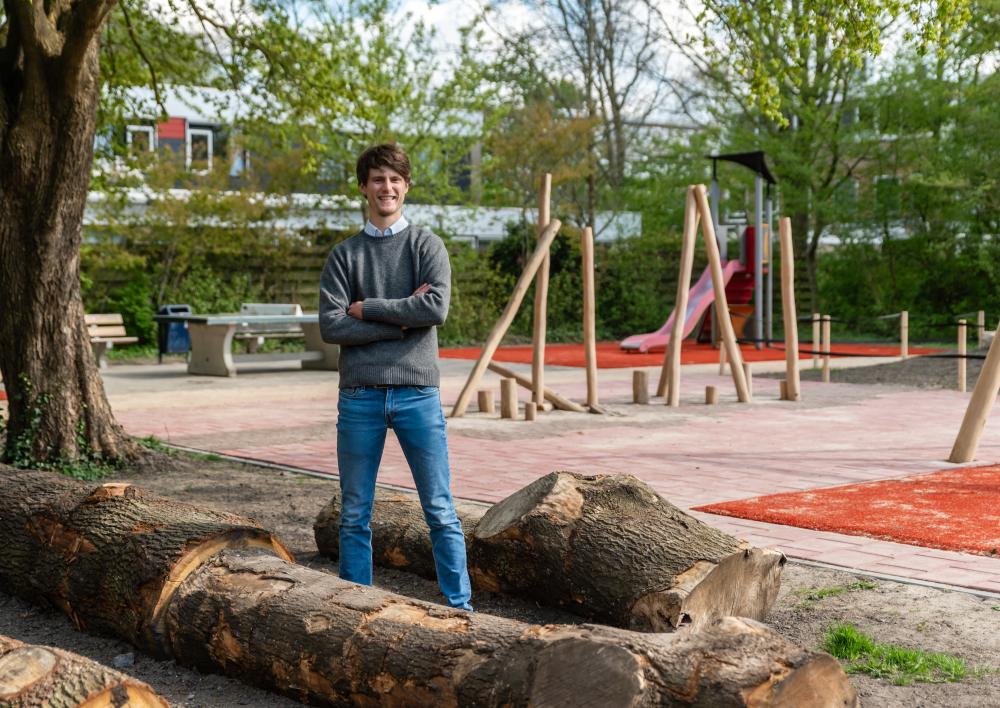 Henri bij een speeltuin tussen de boomstronken