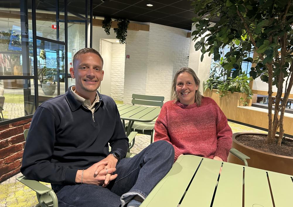 Mitchel en Marga aan een groene tafel in het kantoorpark