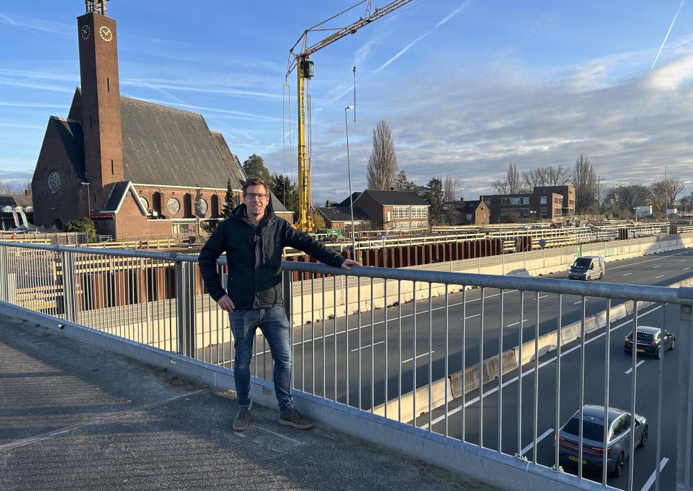 Man staat op brug boven de snelweg