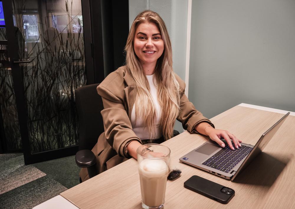 Veerle met een koffie achter de computer