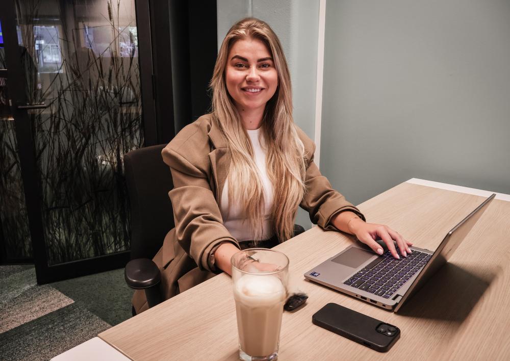 Veerle met een koffie achter de computer