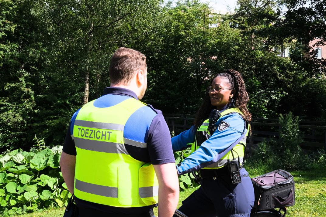Maaike op de fiets in gesprek met een collega