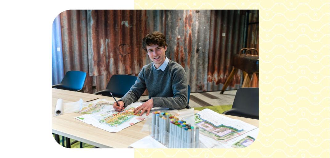 Henri tekent aan tafel in een moderne kantoorruimte