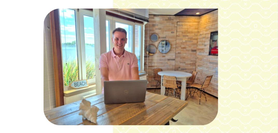 Onno in de koffietuin met thema strand achter de laptop