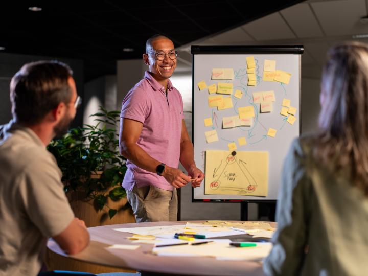 Collega's vergaderen met geeltjes op een flip-over