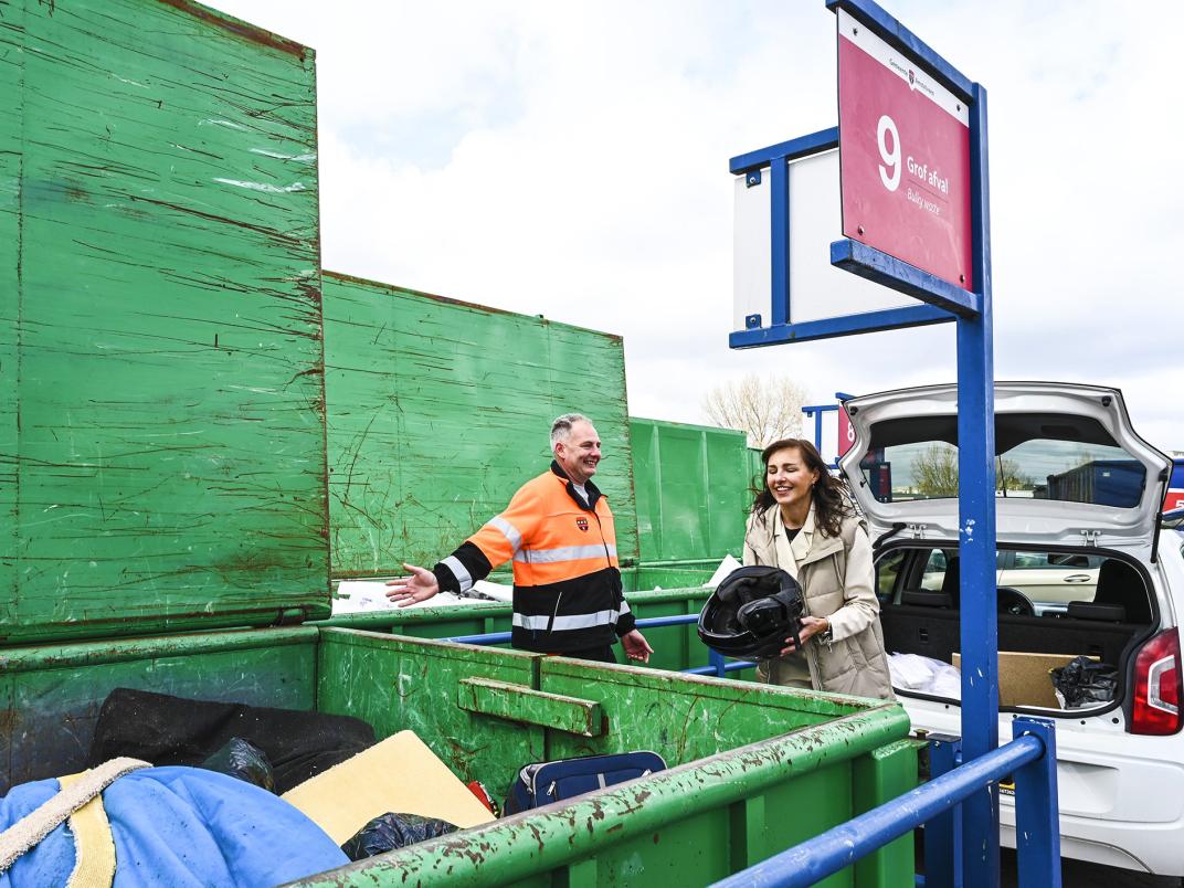 Medewerker van het afvalbrengstation bij een afvalwagen