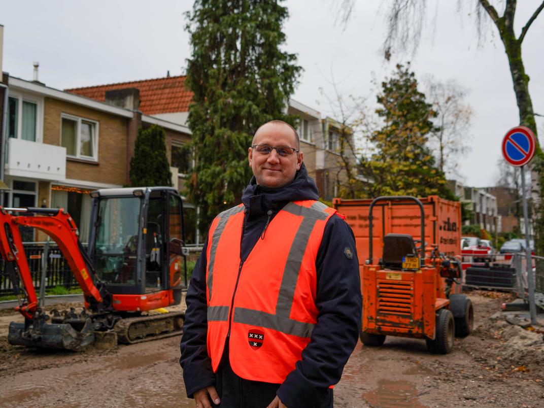 Jacob Pijper staat voor een opengelegde straat met werkzaamheden