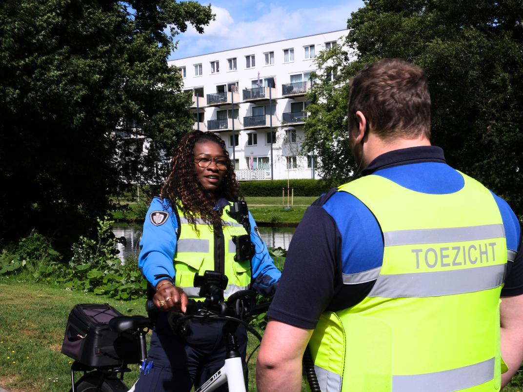 Handhaver Maaike in gesprek met een collega
