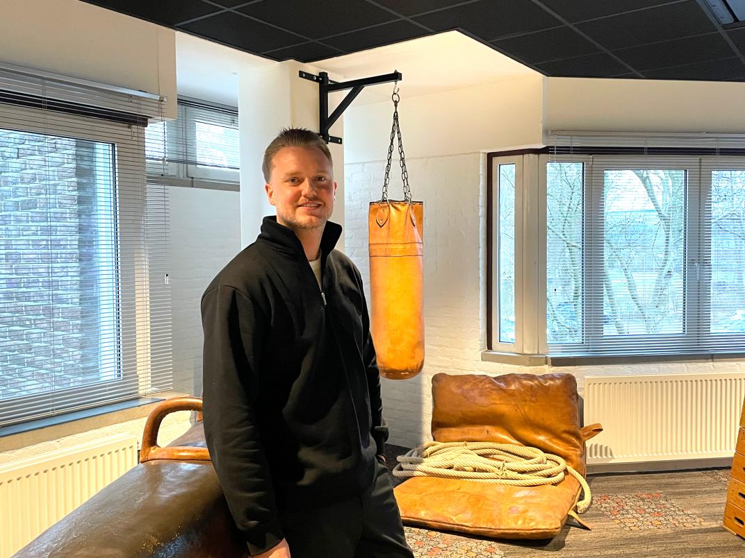 Ruben staat in het kantoorpark met boks kussen