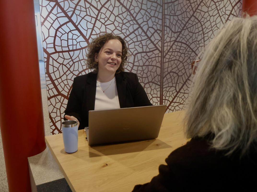 Maxime aan tafel in overleg met een collega