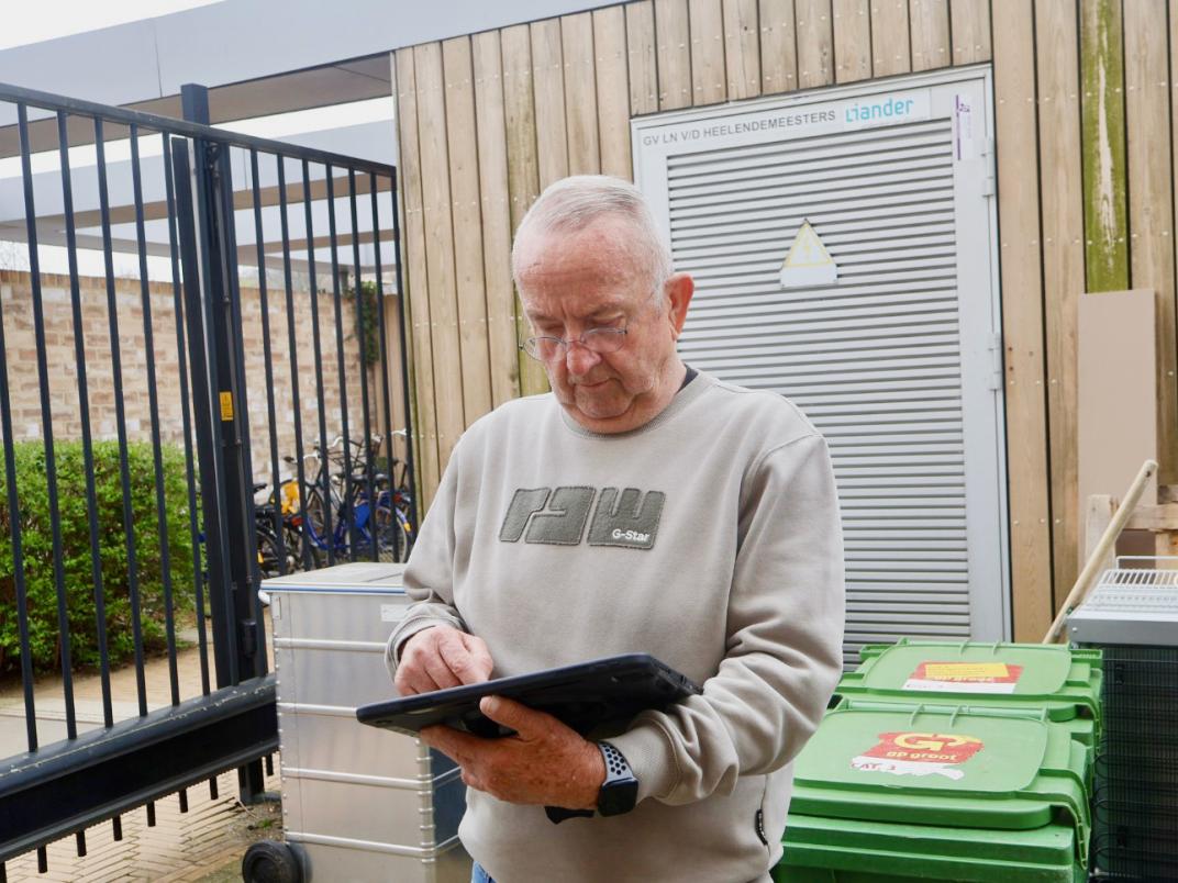 Ron staat buiten en voert iets in op zijn tablet