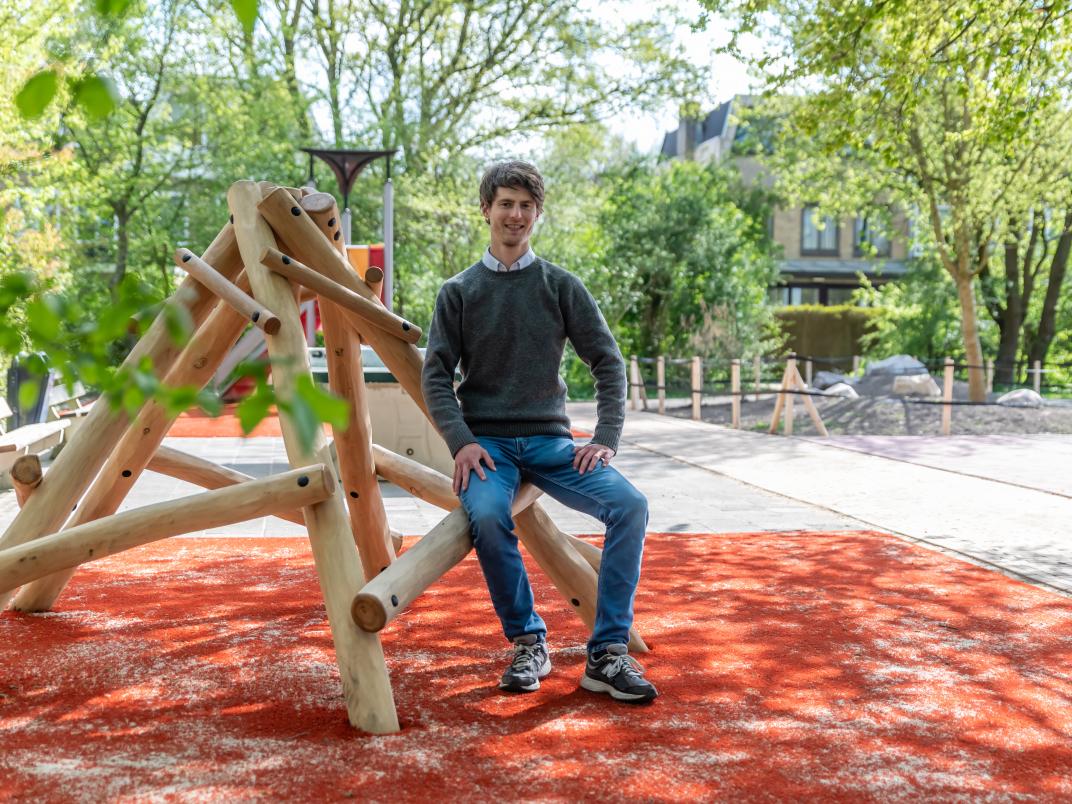 Henri bij de speeltuin tegen een speeltoestel