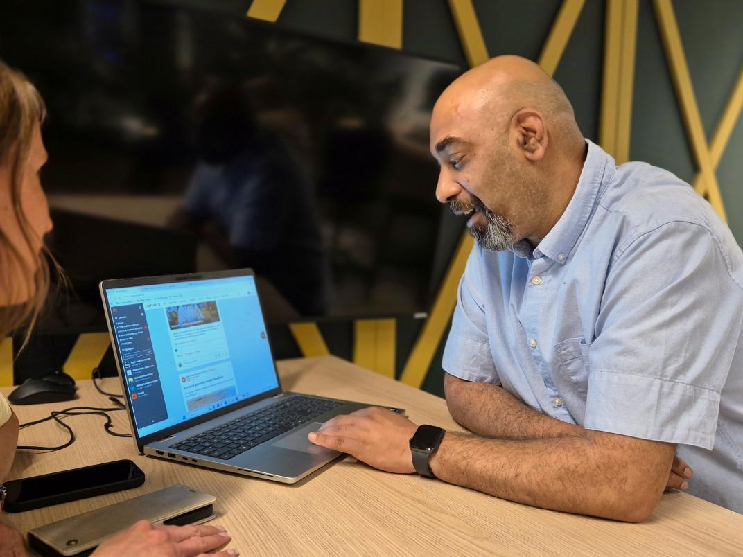 Rayner helpt iemand bij de servicedesk