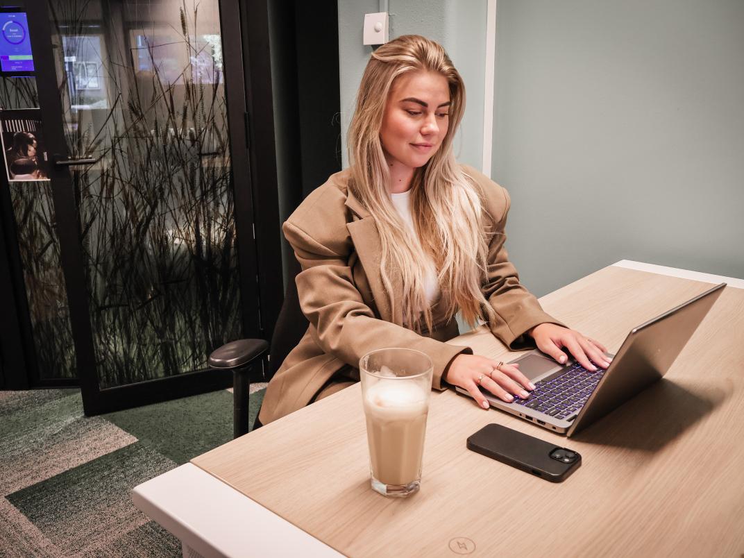 Veerle achter de laptop. Ze kijkt naar het scherm.