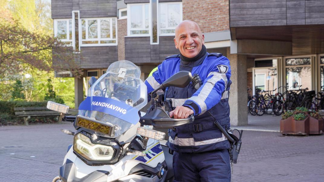 Chokri met zijn dienstmotor voor het raadhuis