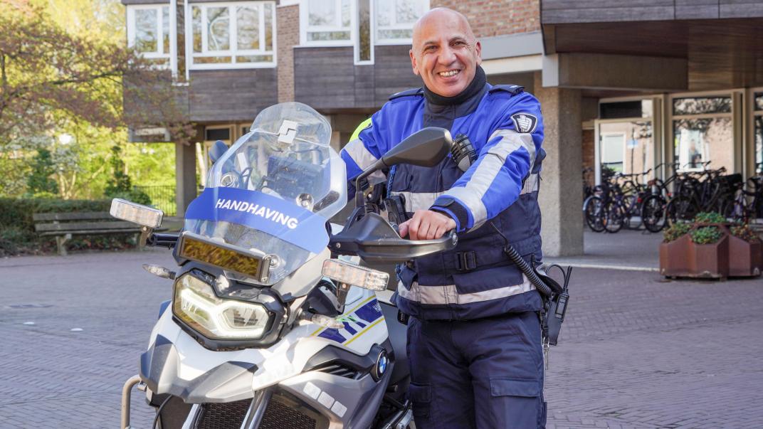 Chokri met zijn dienstmotor voor het raadhuis
