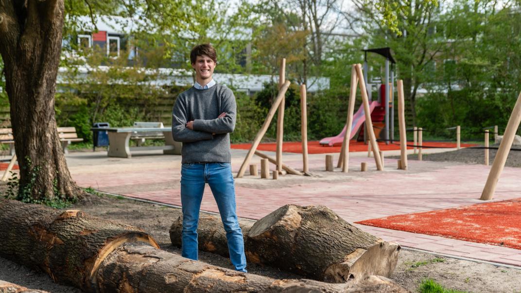 Henri bij een speeltuin tussen de boomstronken
